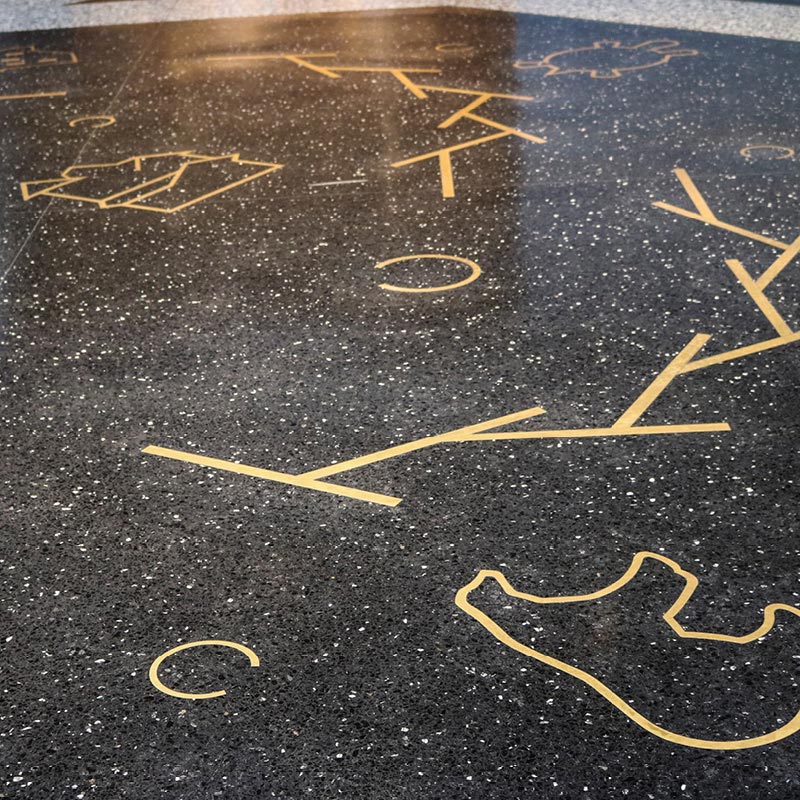 Brass-colored inlays in the marble floor. Floor of Great Hall, Level 1.