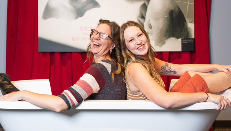 Two visitors sitting in a bathtub at the Julia Child Exhibit.